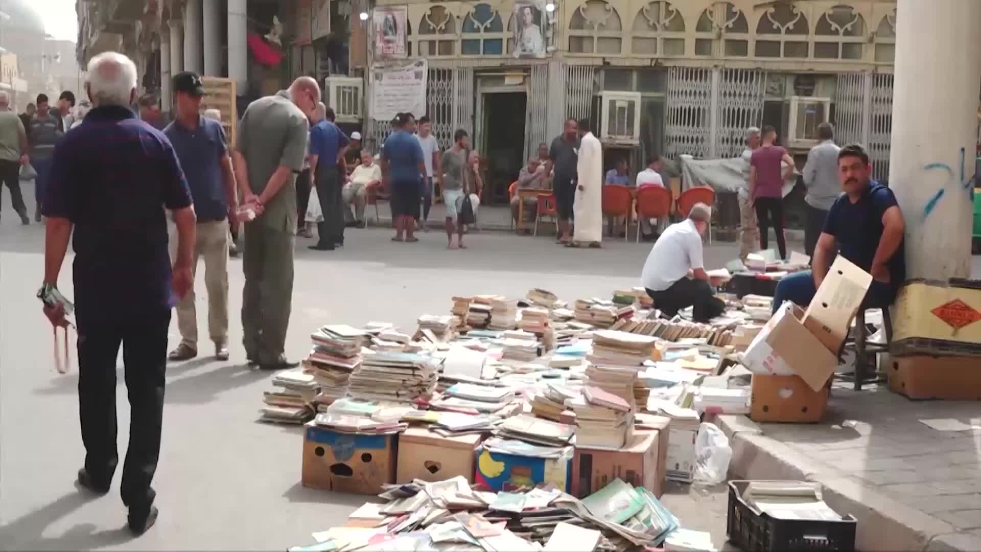 Booksellers laying out stock on the pavement of Al-Mutanabbi Street in Baghdad