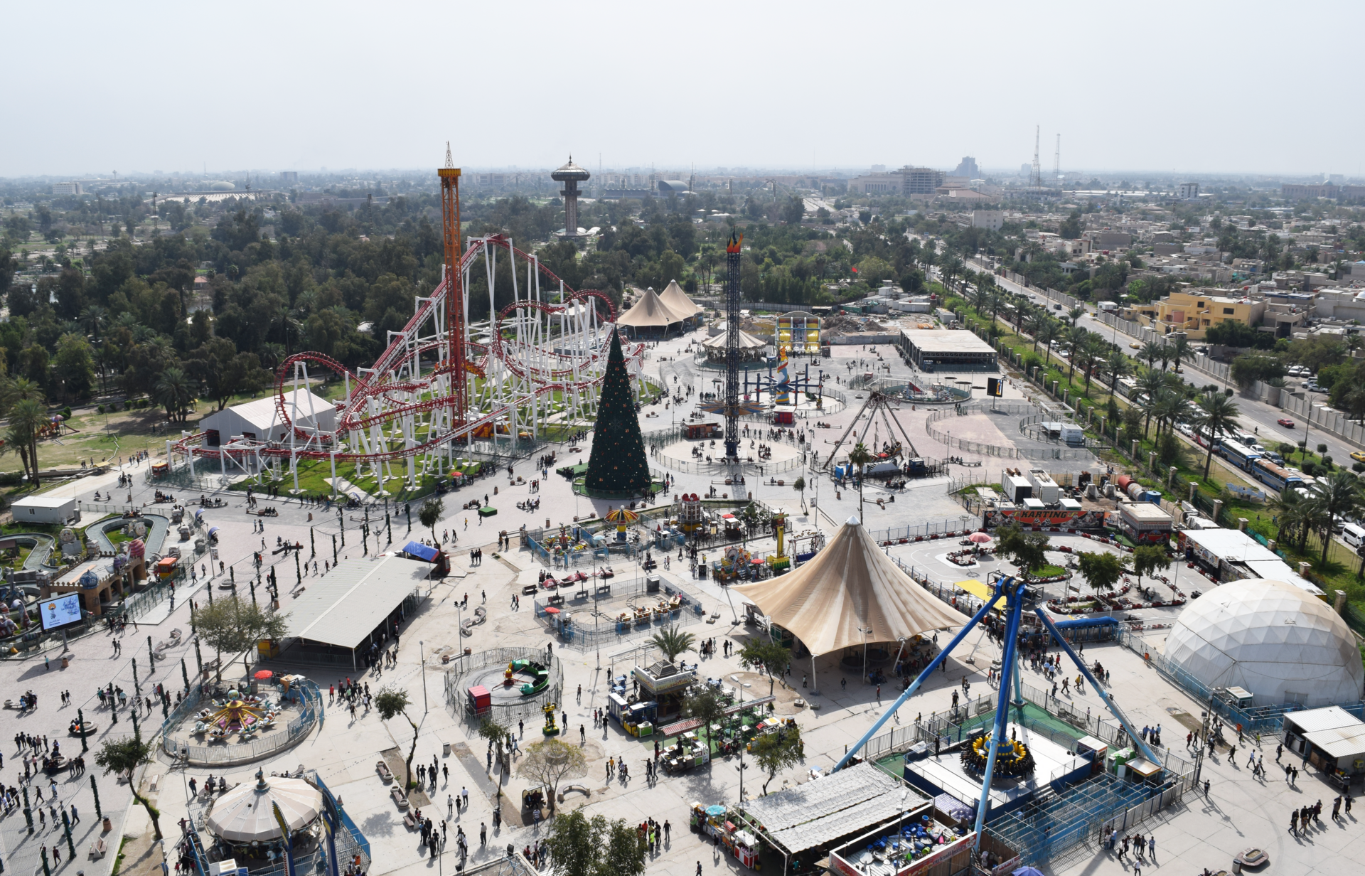 Aerial view of the amusement park inside Al-Zawraa Park in Baghdad, with a roller coaster, fairground rides and crowds
