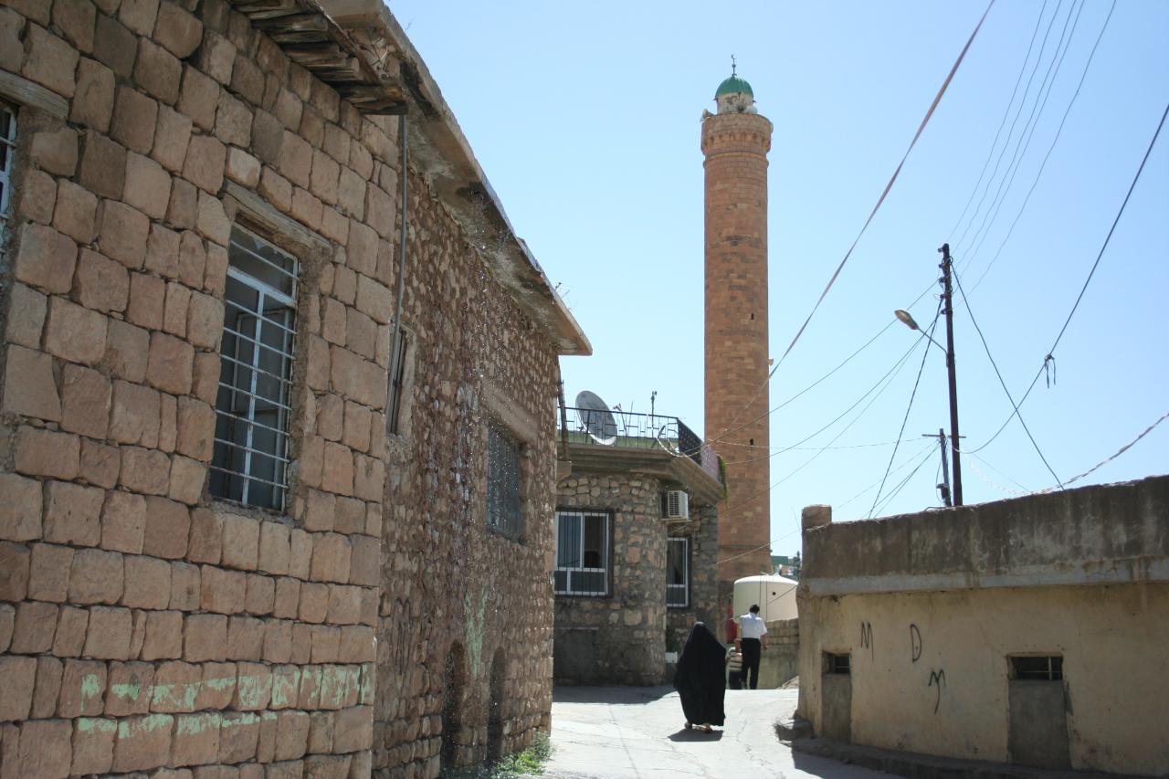 A stone-built lane in Amedi leading towards the tall brick minaret of the town's Great Mosque