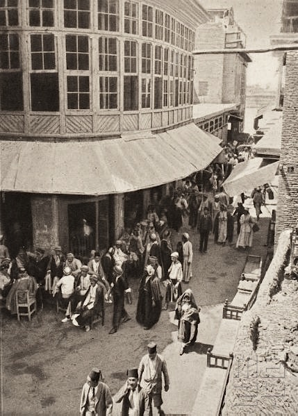 Black and white photograph of a crowded Baghdad street-corner coffee house in the 1920s