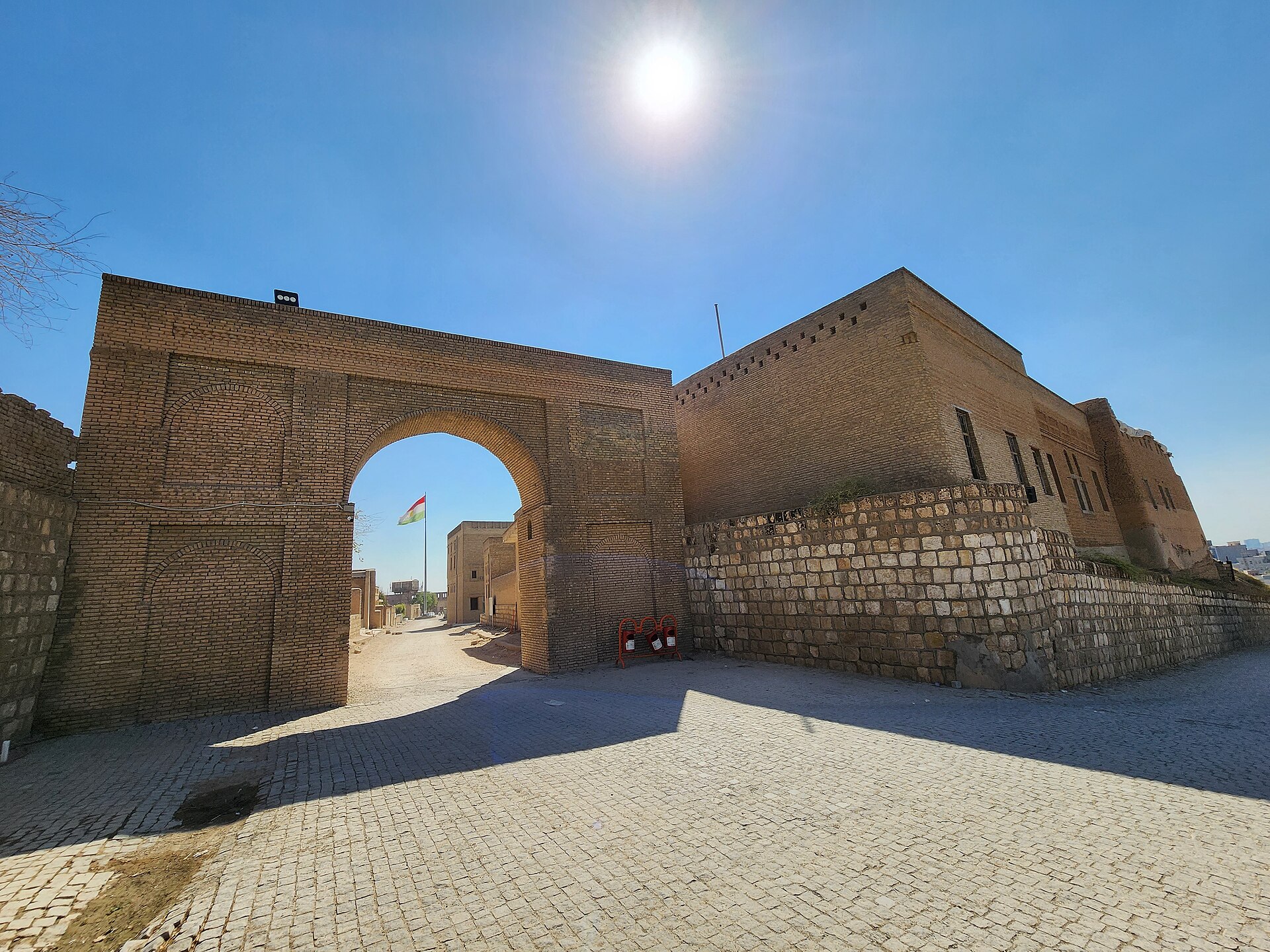 The Ahmadi Gate on the north side of the Erbil Citadel, a plain brick arch above a paved forecourt