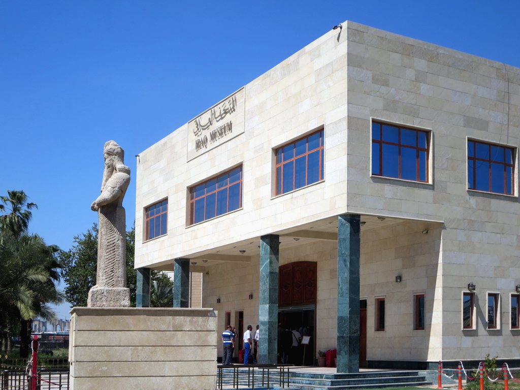 The entrance facade of the Iraq Museum in Baghdad with the Assyrian statue of Nabu standing in front of it