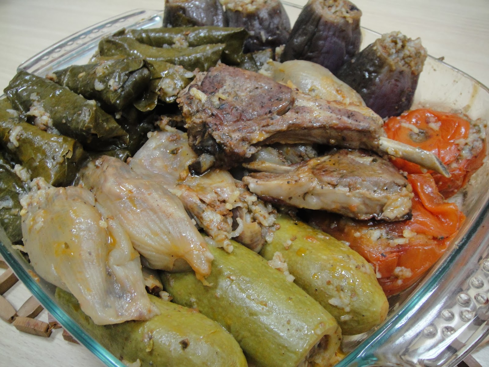 Iraqi dolma with stuffed vine leaves, onion, courgette, aubergine and peppers layered in a dish