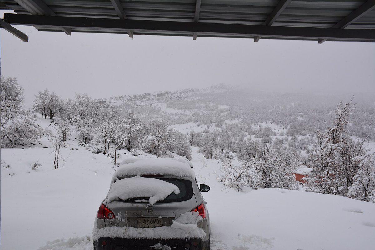 Heavy snow covering a car and hillside in the mountains of Iraqi Kurdistan