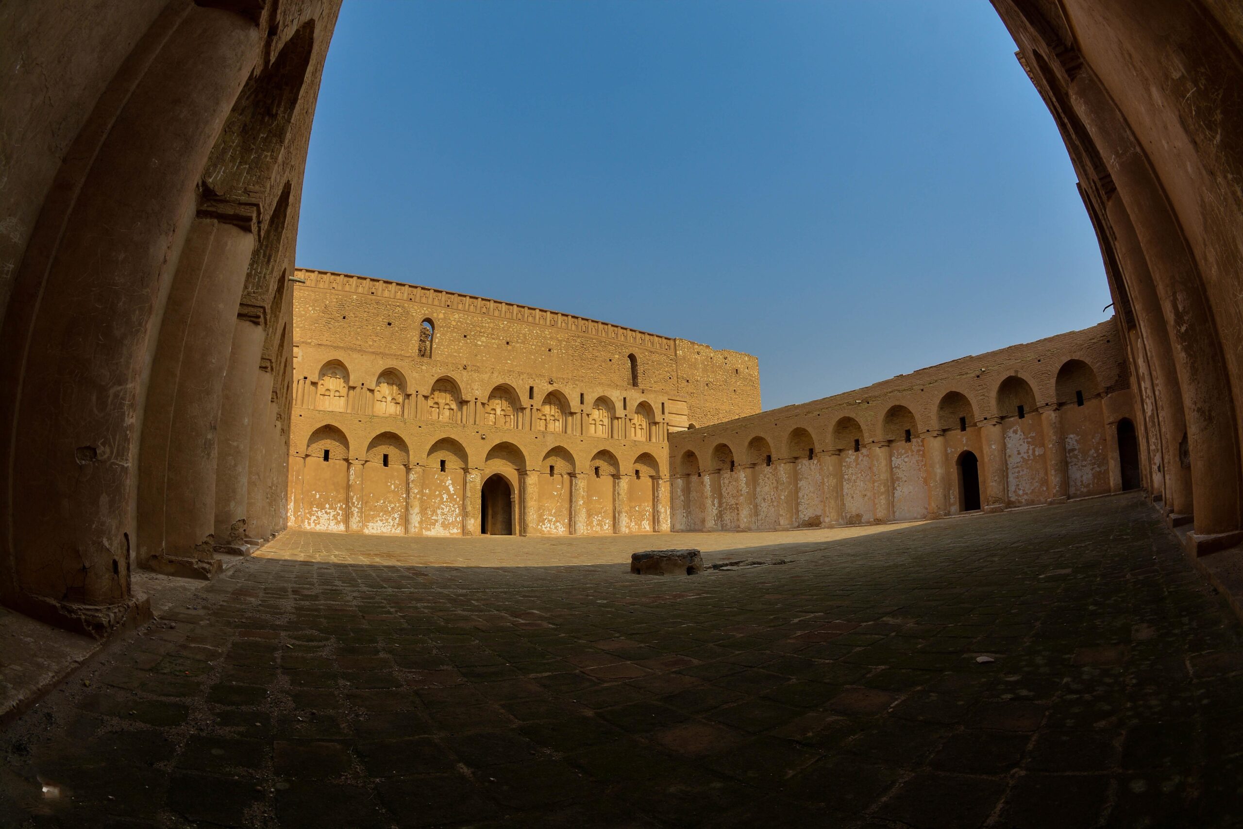 The vaulted arcades and paved courtyard inside Al-Ukhaidir fortress in the Karbala desert
