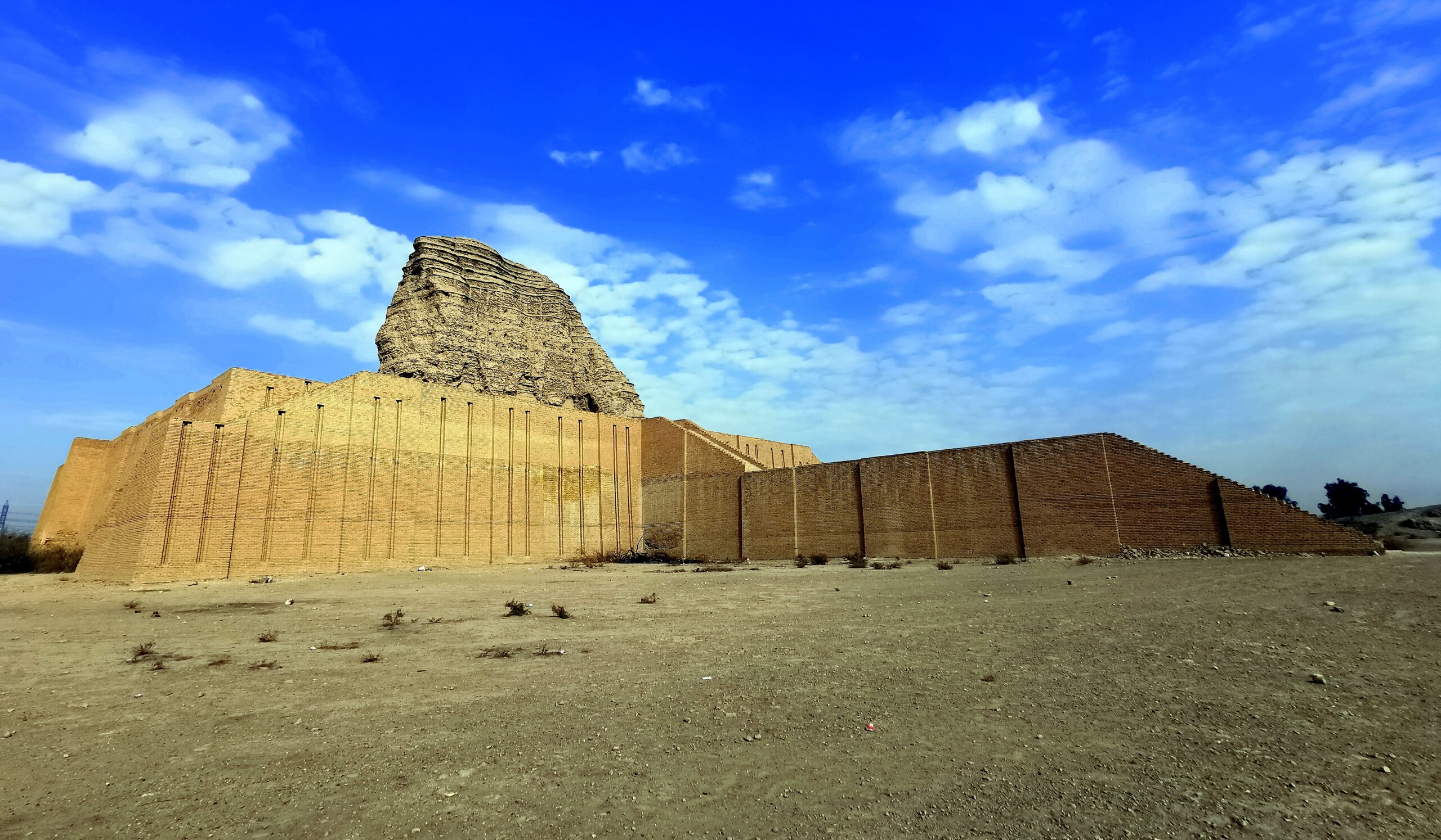 The eroded brick core of the Aqar Quf ziggurat rising above restored lower walls west of Baghdad