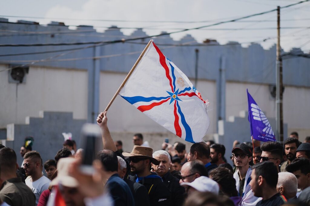 A crowd at the Akitu Assyrian New Year celebrations in Duhok, with an Assyrian flag held high