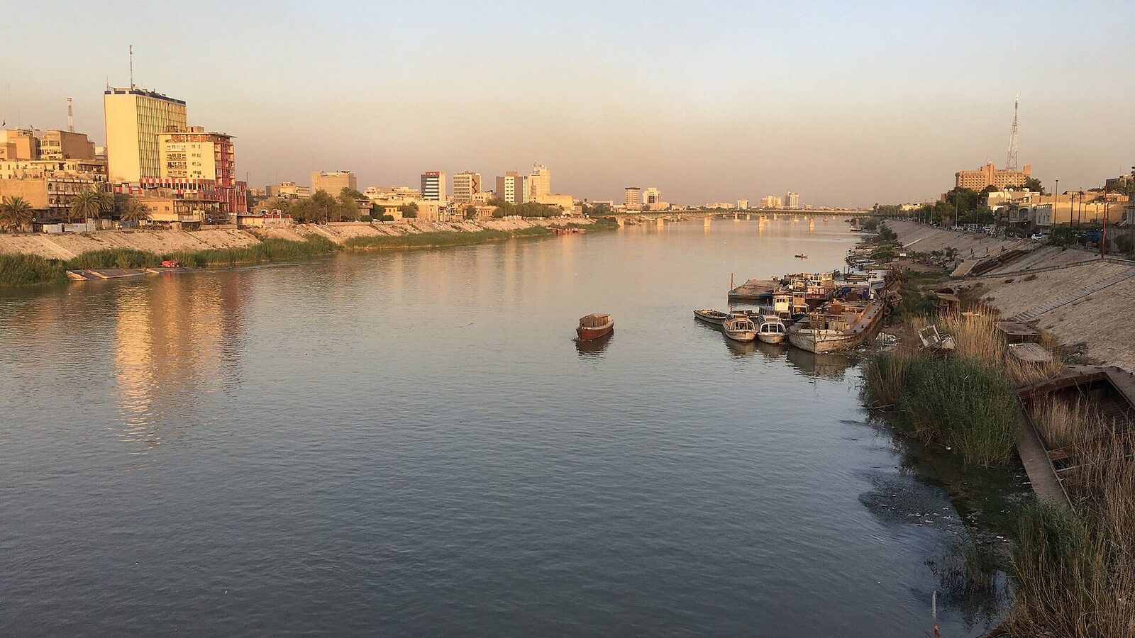 The Tigris at sunset in Baghdad, with boats moored below the riverside buildings on a warm May evening