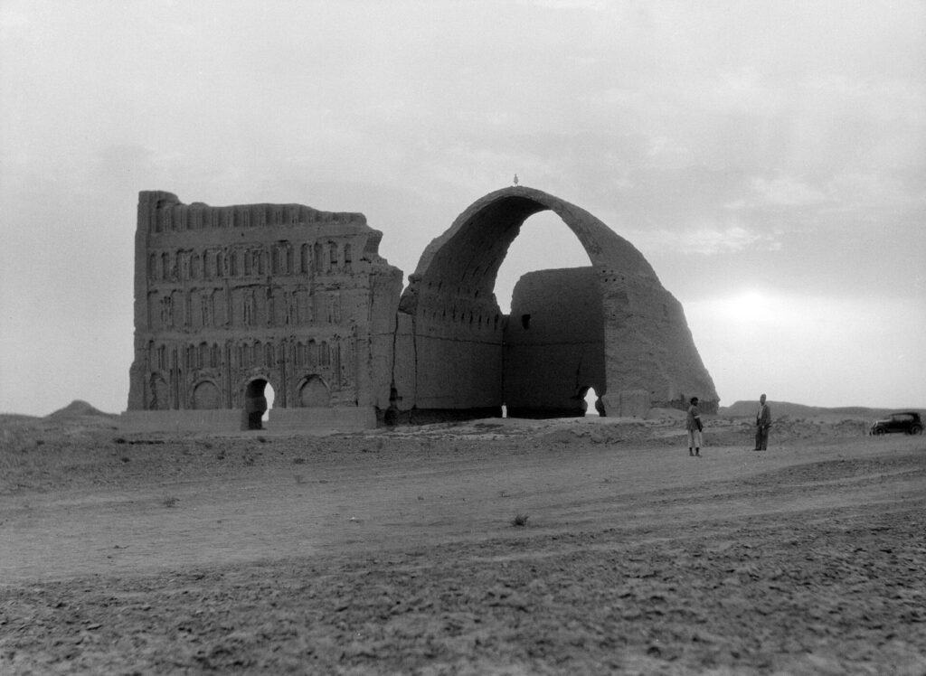Black-and-white photograph of the Taq Kasra arch at Ctesiphon in 1932, with the south façade standing and the north wing gone
