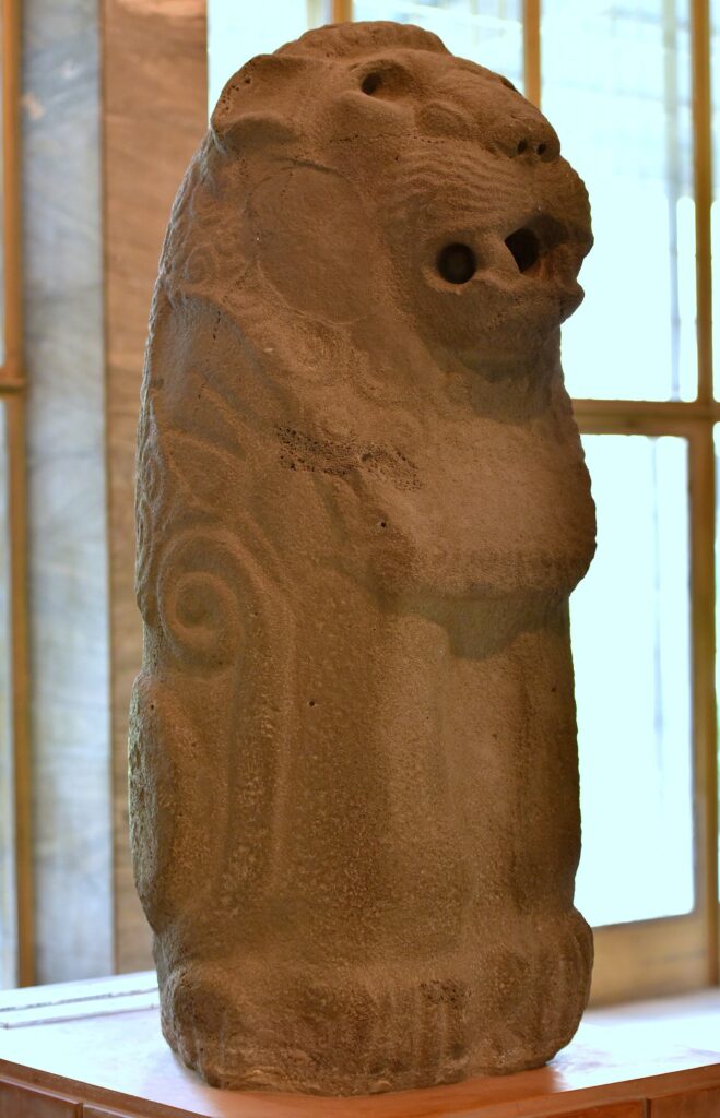 Weathered basalt statue of a standing lion from Eridu, displayed in the Iraq Museum
