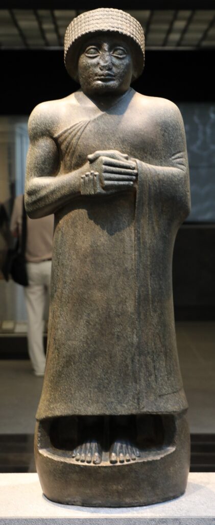 Black diorite statue of Gudea, ruler of Lagash, from Girsu, standing with his hands clasped