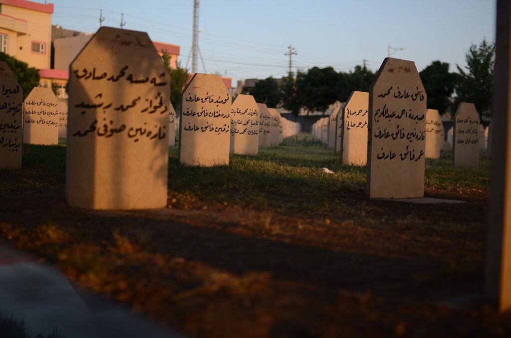 Rows of inscribed gravestones in the Halabja martyrs' cemetery at sunset