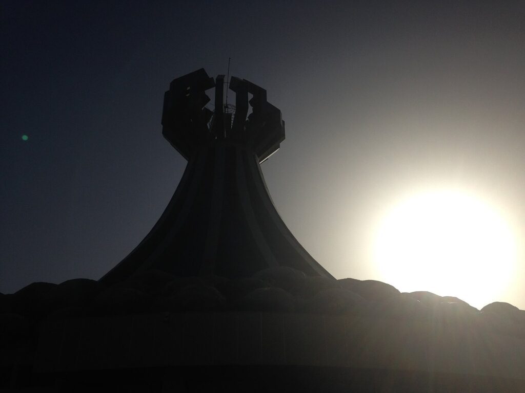 The flared tower of the Halabja Monument silhouetted against the setting sun