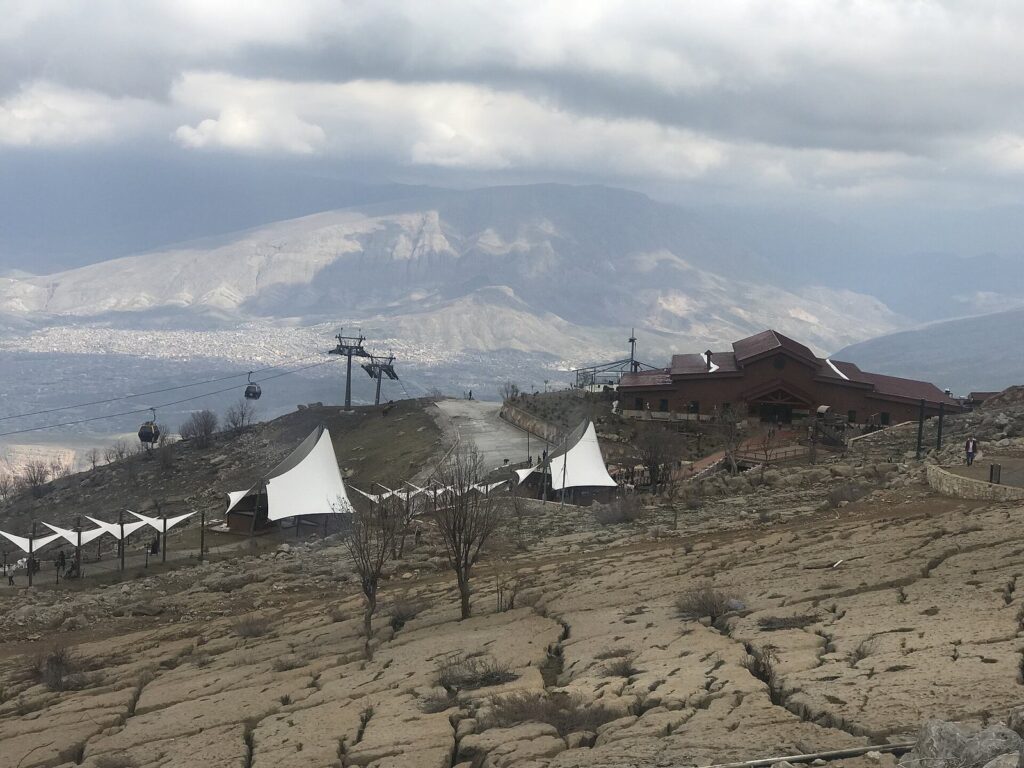 The Korek cable car's top-station area with gondola pylons, white tents and a restaurant