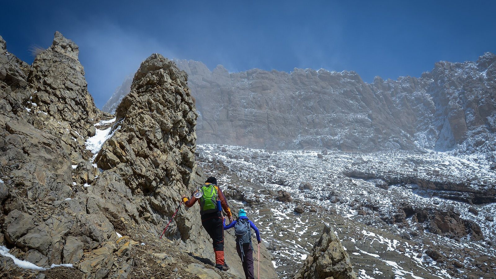 Kurdistan hiking: two walkers on the rocky, snow-dusted flanks of Piramagrun mountain