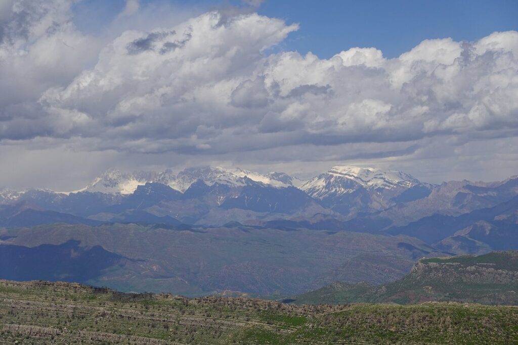 Snow on the peaks and green hills below in the Kurdistan Region in spring, a classic view of Iraq in spring