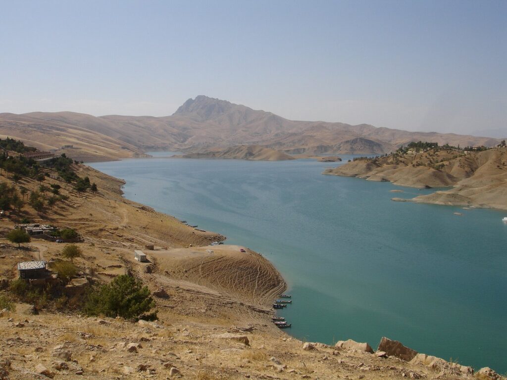 Lake Dukan in August with bare brown hills around the shoreline and a mountain behind, the dry face of Kurdistan seasons