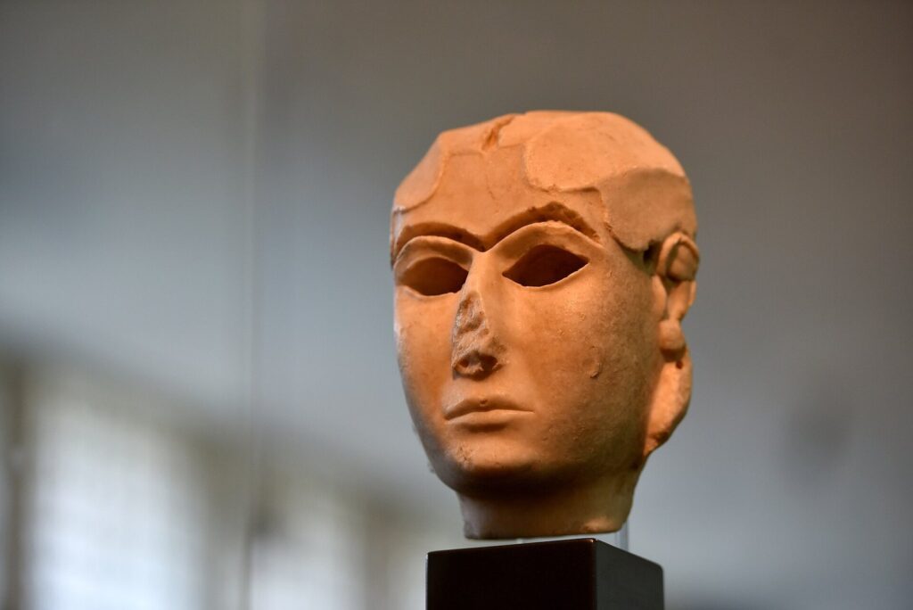 The Mask of Warka, a carved marble woman's face from Uruk, on a plinth in the Iraq Museum