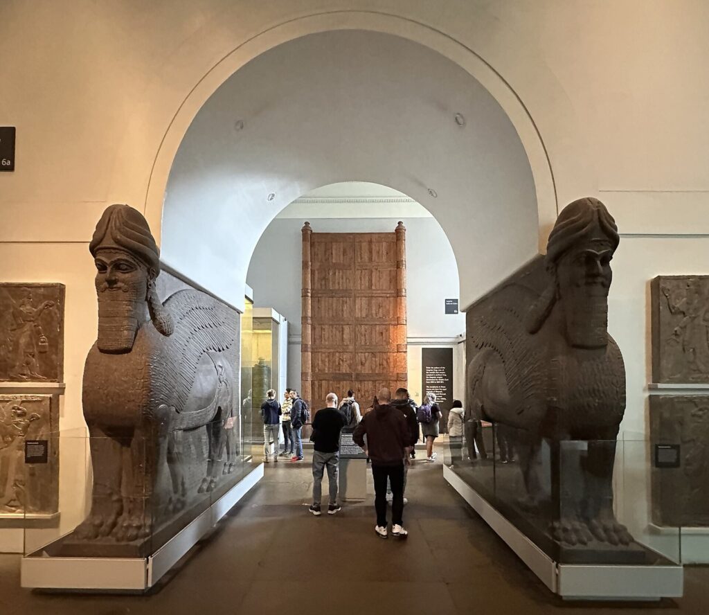 A pair of colossal winged human-headed lamassu from the Northwest Palace at Nimrud flanking a gallery doorway in the British Museum