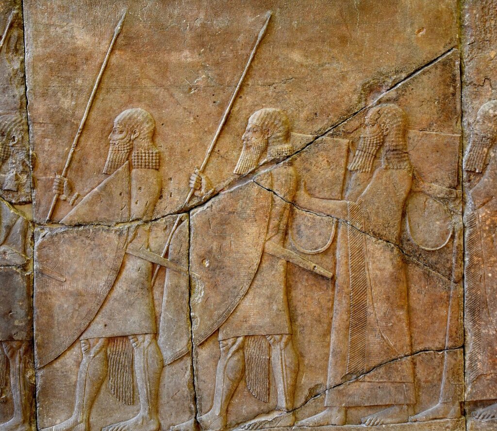 Assyrian alabaster relief of two soldiers and two musicians with drums, from Sennacherib's reign at Nineveh