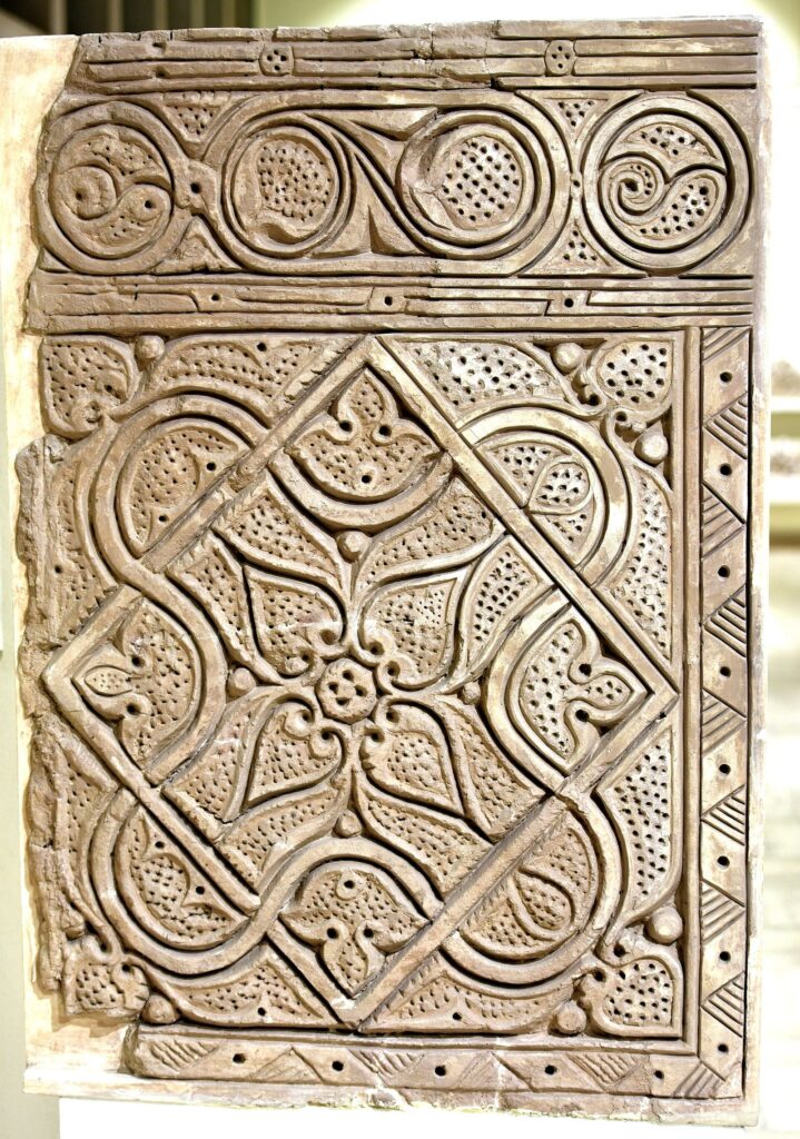 A carved ninth-century stucco panel from Samarra with interlaced geometric and floral patterns