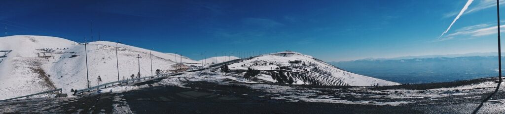Snow-covered mountains above Sulaymaniyah under a clear blue winter sky in Iraqi Kurdistan