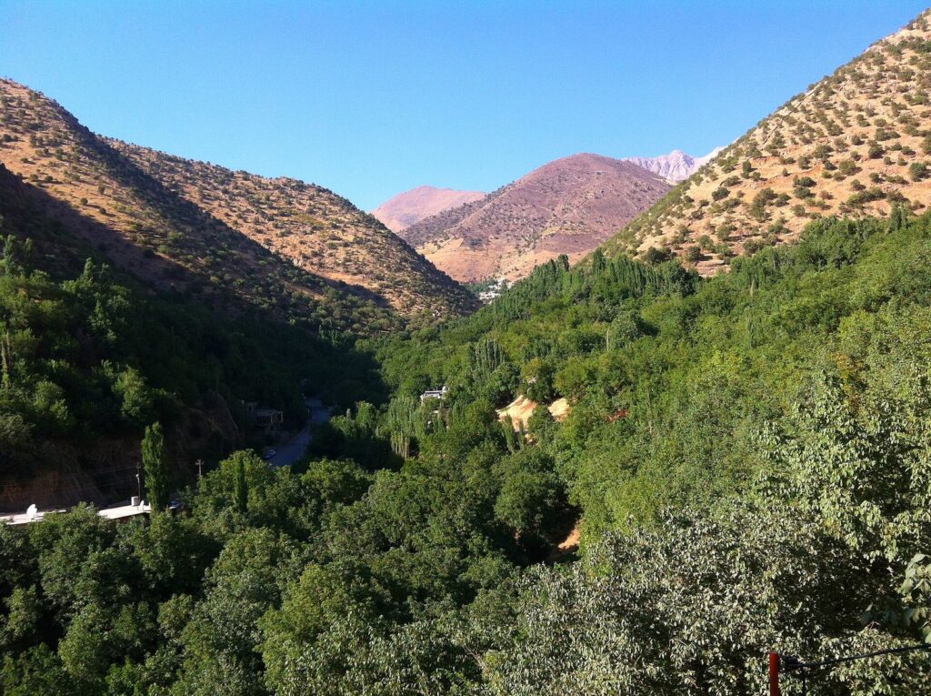 The green Hawraman valley at Tawela with wooded slopes and bare peaks behind