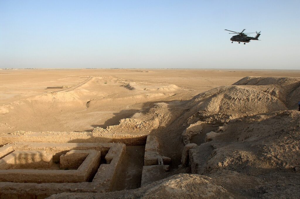 Excavated mud-brick foundations and eroded mounds at the Uruk ruins at Warka, in flat desert