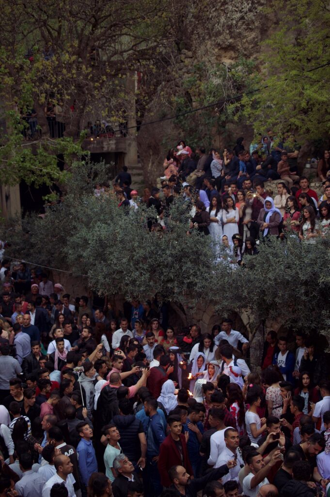 Crowds of Yazidis gathered among the trees and buildings of Lalish on the eve of the Yazidi New Year