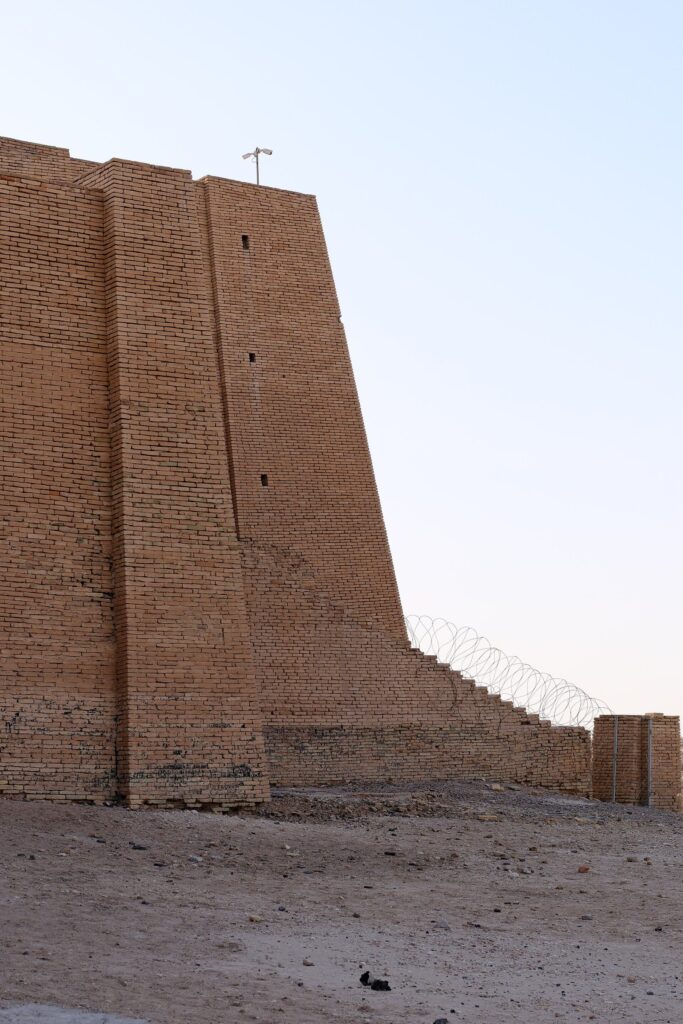 A corner of the Ziggurat of Ur with razor wire along its upper edge